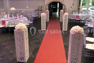 Cuillères transparentes disposées en cercle sur une assiette noire, remplies de semoule garnie de légumes et herbes.