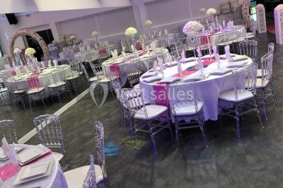 Cuillères transparentes disposées en cercle sur une assiette noire, remplies de semoule garnie de légumes et herbes.