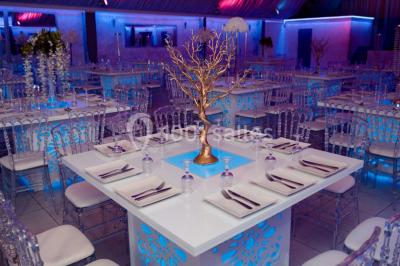 Cuillères transparentes disposées en cercle sur une assiette noire, remplies de semoule garnie de légumes et herbes.