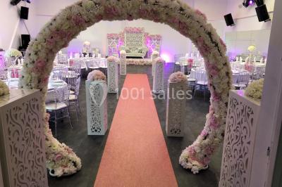 Cuillères transparentes disposées en cercle sur une assiette noire, remplies de semoule garnie de légumes et herbes.