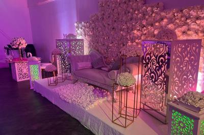 Cuillères transparentes disposées en cercle sur une assiette noire, remplies de semoule garnie de légumes et herbes.