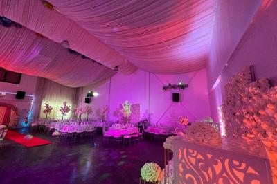 Cuillères transparentes disposées en cercle sur une assiette noire, remplies de semoule garnie de légumes et herbes.