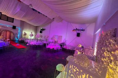 Cuillères transparentes disposées en cercle sur une assiette noire, remplies de semoule garnie de légumes et herbes.