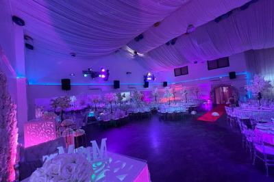 Cuillères transparentes disposées en cercle sur une assiette noire, remplies de semoule garnie de légumes et herbes.