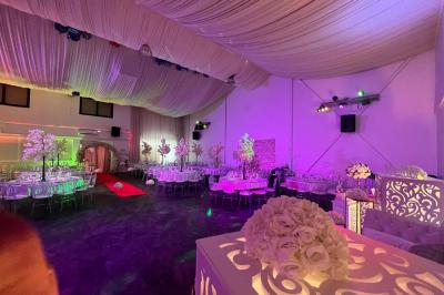 Cuillères transparentes disposées en cercle sur une assiette noire, remplies de semoule garnie de légumes et herbes.