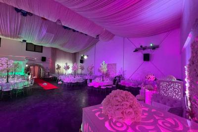 Cuillères transparentes disposées en cercle sur une assiette noire, remplies de semoule garnie de légumes et herbes.