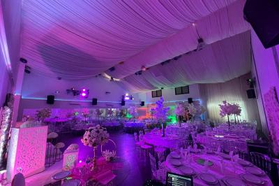 Cuillères transparentes disposées en cercle sur une assiette noire, remplies de semoule garnie de légumes et herbes.