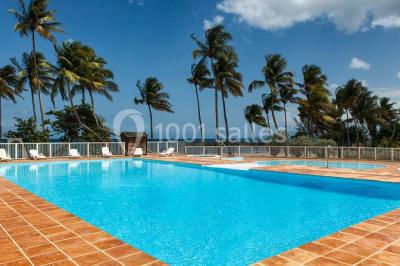 Deux tasses blanches avec cuillères sur un plateau, posées sur une table près d'une lampe dans une chambre lumineuse.