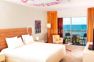 Deux tasses blanches avec cuillères sur un plateau, posées sur une table près d'une lampe dans une chambre lumineuse.