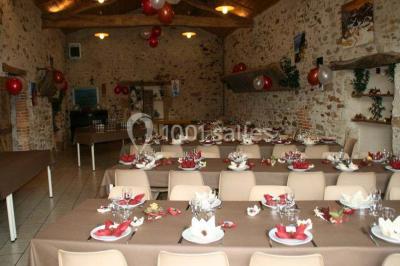 Allée asphaltée éclairée par des lampes extérieures, bordée de plantes et menant à une maison dans l'obscurité.