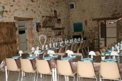 Allée asphaltée éclairée par des lampes extérieures, bordée de plantes et menant à une maison dans l'obscurité.