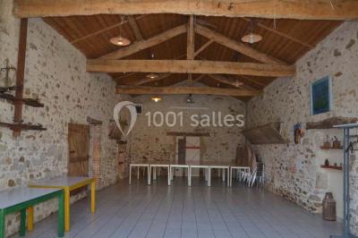 Allée asphaltée éclairée par des lampes extérieures, bordée de plantes et menant à une maison dans l'obscurité.