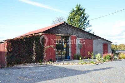 Allée asphaltée éclairée par des lampes extérieures, bordée de plantes et menant à une maison dans l'obscurité.