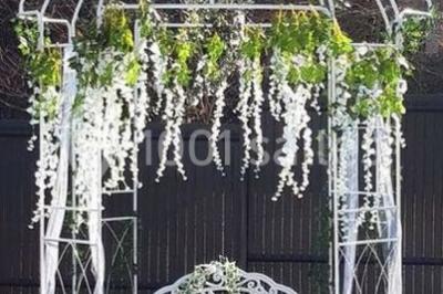 Salle lumineuse avec tables décorées de nappes blanches et chemins de table verts, prête pour un événement.