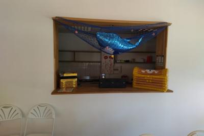 Salle lumineuse avec tables décorées de nappes blanches et chemins de table verts, prête pour un événement.