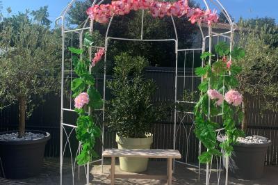 Salle lumineuse avec tables décorées de nappes blanches et chemins de table verts, prête pour un événement.