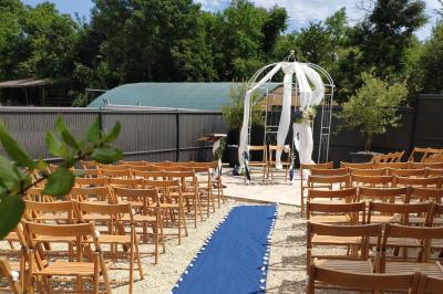 Salle lumineuse avec tables décorées de nappes blanches et chemins de table verts, prête pour un événement.