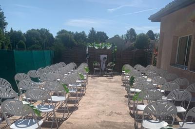 Salle lumineuse avec tables décorées de nappes blanches et chemins de table verts, prête pour un événement.
