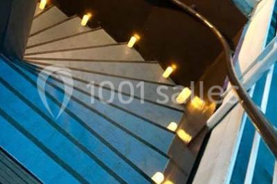 Personnes dansant dans une salle faiblement éclairée avec des lumières colorées créant une ambiance festive.