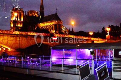 Personnes dansant dans une salle faiblement éclairée avec des lumières colorées créant une ambiance festive.