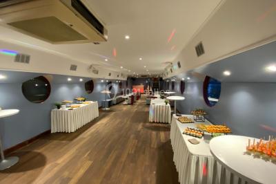 Personnes dansant dans une salle faiblement éclairée avec des lumières colorées créant une ambiance festive.