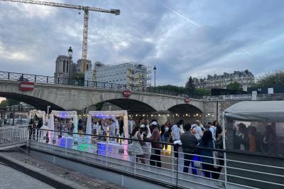 Personnes dansant dans une salle faiblement éclairée avec des lumières colorées créant une ambiance festive.