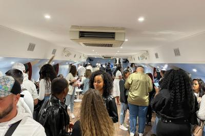 Personnes dansant dans une salle faiblement éclairée avec des lumières colorées créant une ambiance festive.