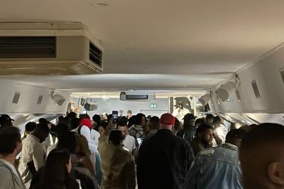 Personnes dansant dans une salle faiblement éclairée avec des lumières colorées créant une ambiance festive.