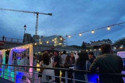 Personnes dansant dans une salle faiblement éclairée avec des lumières colorées créant une ambiance festive.