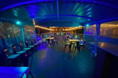 Personnes dansant dans une salle faiblement éclairée avec des lumières colorées créant une ambiance festive.