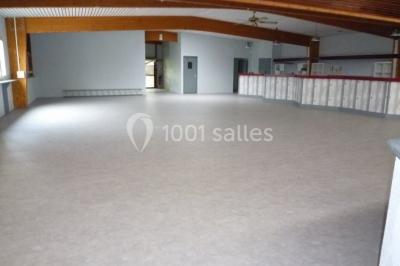 Bar avec éclairage rouge, comptoir en bois, étagères avec verres et décorations, ambiance tamisée.