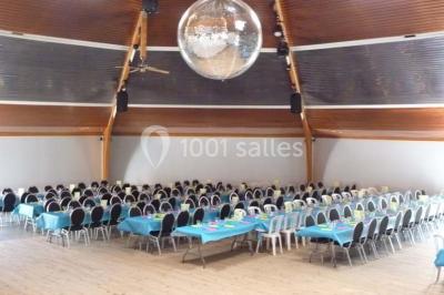 Bar avec éclairage rouge, comptoir en bois, étagères avec verres et décorations, ambiance tamisée.