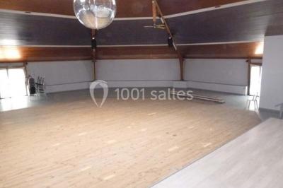 Bar avec éclairage rouge, comptoir en bois, étagères avec verres et décorations, ambiance tamisée.