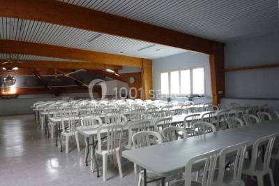 Bar avec éclairage rouge, comptoir en bois, étagères avec verres et décorations, ambiance tamisée.
