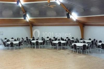 Bar avec éclairage rouge, comptoir en bois, étagères avec verres et décorations, ambiance tamisée.