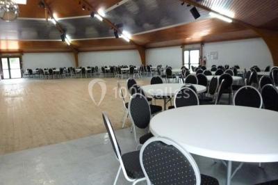 Bar avec éclairage rouge, comptoir en bois, étagères avec verres et décorations, ambiance tamisée.