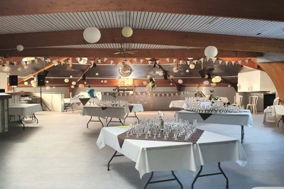 Bar avec éclairage rouge, comptoir en bois, étagères avec verres et décorations, ambiance tamisée.