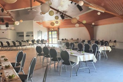Bar avec éclairage rouge, comptoir en bois, étagères avec verres et décorations, ambiance tamisée.