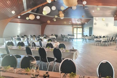 Bar avec éclairage rouge, comptoir en bois, étagères avec verres et décorations, ambiance tamisée.