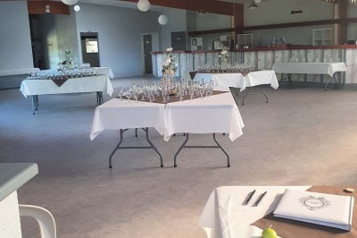 Bar avec éclairage rouge, comptoir en bois, étagères avec verres et décorations, ambiance tamisée.