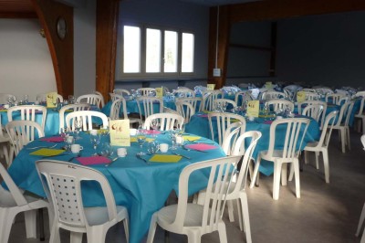 Bar avec éclairage rouge, comptoir en bois, étagères avec verres et décorations, ambiance tamisée.