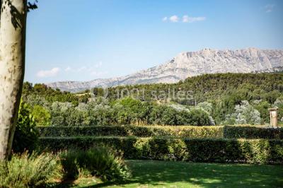 Chambre lumineuse avec murs orange, lit double, sol en terre cuite, table près d'une fenêtre et cloison en bois.