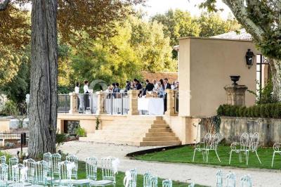 Chambre lumineuse avec murs orange, lit double, sol en terre cuite, table près d'une fenêtre et cloison en bois.