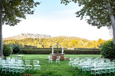Chambre lumineuse avec murs orange, lit double, sol en terre cuite, table près d'une fenêtre et cloison en bois.