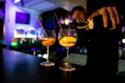 Maison entourée de verdure avec un chemin en gravier, des arbres et une terrasse visible en arrière-plan.