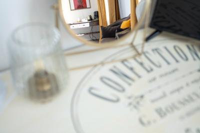 Maison entourée de verdure avec un chemin en gravier, des arbres et une terrasse visible en arrière-plan.