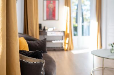 Maison entourée de verdure avec un chemin en gravier, des arbres et une terrasse visible en arrière-plan.