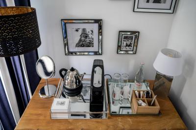 Maison entourée de verdure avec un chemin en gravier, des arbres et une terrasse visible en arrière-plan.