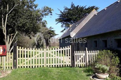 Miniature Location salle Gouesnou (Finistère) - La Cour des Grands #24 Allée bordée de buis en pots et d'un mur en pierre, avec pelouse et arbres en arrière-plan.