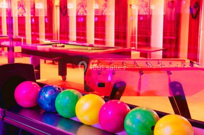 Entrée d'un espace moderne avec éclairage bleu, tapis rouge et panneau lumineux affichant un logo.